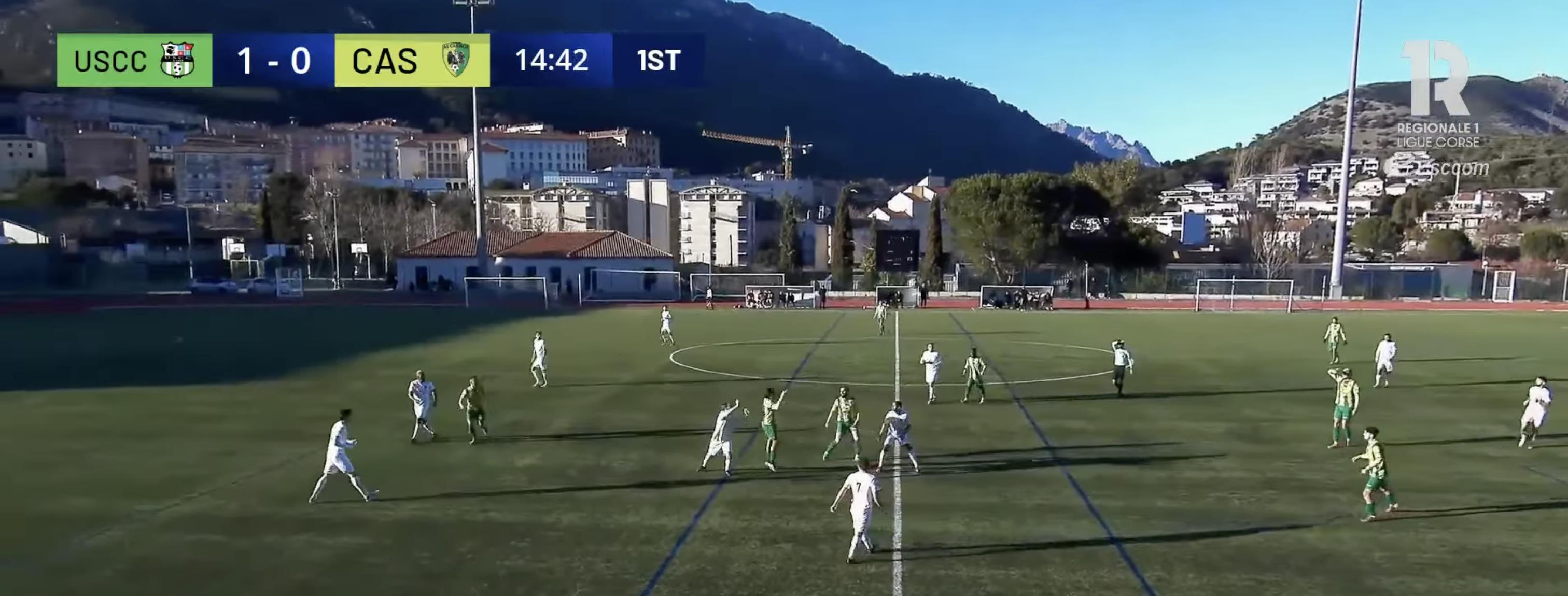 Live Corsican football match with LIGR broadcast graphics overlay and mountain backdrop